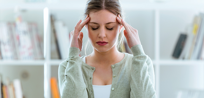  jeune femme avec une migraine qui masse ses tempes